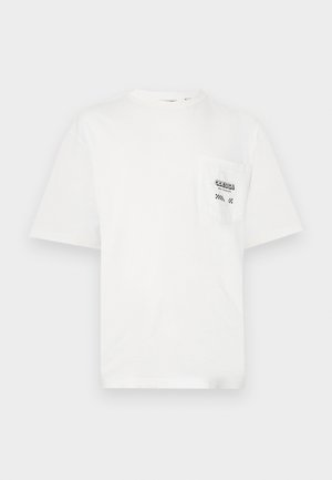 Vit bomulls t-shirt med rund hals, korta ärmar och bröstficka till vänster som har texten "ODESSA" och rutiga detaljer.