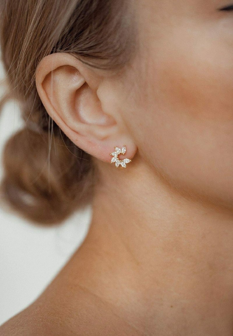 Boucles d'oreilles en or et cristal en forme de fleur, présentant un design à plusieurs pétales, avec des accents transparents et une fermeture arrière sécurisée.