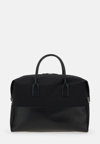 Svart duffelväska av nylon med läderdetaljer, rektangulär form, utrustad med två handtag och dragkedjestängning. Slät yta.