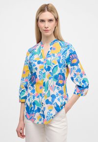 Blumenbluse mit einem blau-gelben und pinken Muster, ausgestattet mit einem Kragen und Dreiviertelärmeln, aus leichtem Stoff gefertigt.