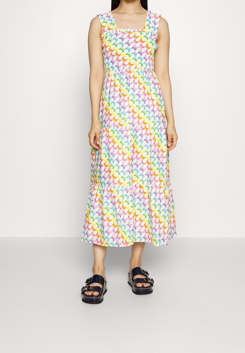 Robe maxi avec un décolleté carré, des bretelles volantées et un motif tissé coloré en teintes pastel ; ourlet en couches, associée à des sandales sombres.