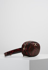 Borsa in pelle stampa pitone rossa e nera con forma arrotondata, chiusura doppia con zip, dettagli in metallo dorato e tracolla regolabile.