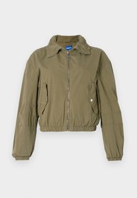 Giacca bomber verde oliva tagliata con zip frontale, due tasche laterali, polsini arricciati e colletto alto. Realizzata in tessuto leggero.