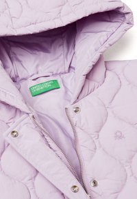 Giacca trapuntata lavanda con cappuccio, zip argentata, bottoni automatici e un'etichetta verde con "UNITED COLORS OF BENETTON" all'interno.