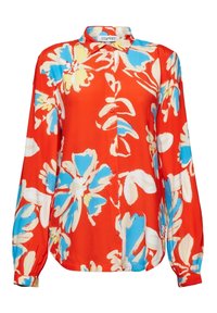 Blouse rouge à fleurs avec de grosses fleurs bleues et blanches, manches longues, col à revers et boutons sur le devant. Tissu lisse, coupe décontractée.