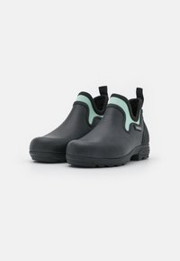 Black rubber ankle boots with a mint green accent along the top edge, featuring a textured finish and a pull tab at the back for easy wear.
