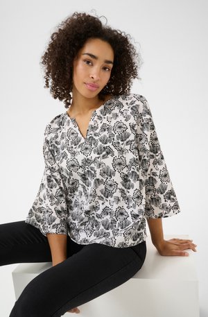 Black and white floral print blouse with a V-neckline and three-quarter sleeves. Lightweight fabric with a smooth texture.