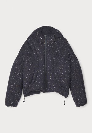 Chaqueta acolchada y recortada en azul marino con capucha, con lunares blancos y dorados. Acentos elásticos en los puños y el dobladillo. Cierre frontal con cremallera.