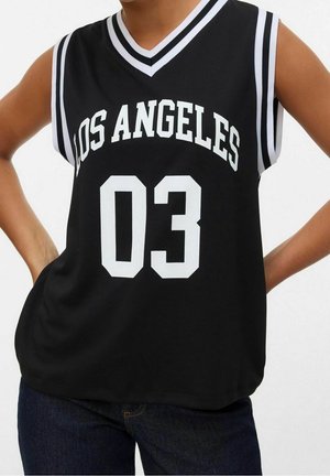 Musta hihaton pelipaita, jossa valkoinen teksti "LOS ANGELES" ja numero "03." Paidassa on V-aukko ja olkapäillä raidalliset korostukset.