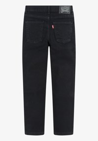 Black denim jeans with a straight leg design, featuring two back pockets and a label at the waist. Textured fabric with a smooth finish.