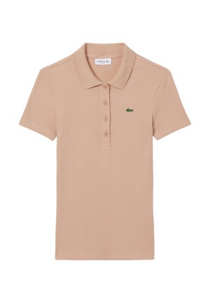 Pale pink ribbed polo shirt, short sleeves, classic collar, three-button placket, and green Lacoste logo on the left chest.