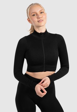 Schwarzes, geripptes Langarm-Crop-Top mit hohem Kragen und Frontreißverschluss. Der Stoff wirkt dehnbar und bequem, ideal für Sportbekleidung.