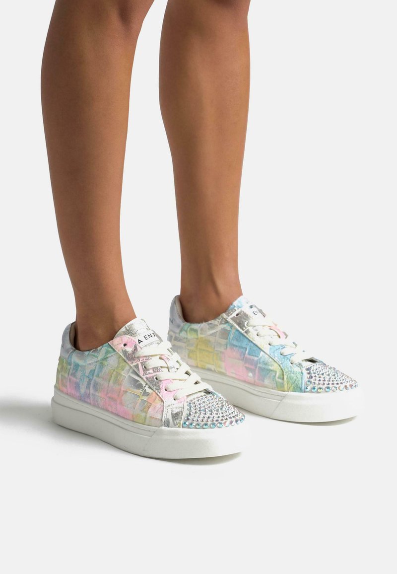 Zapatillas iridiscentes con un patrón texturizado similar al cocodrilo; acentos plateados, cordones rosa y una punta con tachuelas; suela de goma blanca.