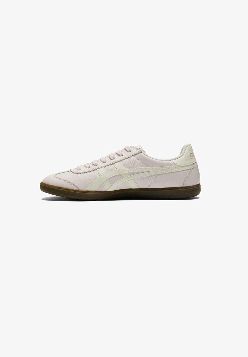 Light pink sneakers with a smooth leather upper, white accent stripes, and brown rubber sole; classic lace-up design, minimalist style.