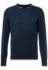 Suéter azul marino de cuello redondo hecho con tela texturizada, con un pequeño logo y ribetes contrastantes en rojo y blanco en los puños y el dobladillo.