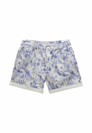 Nahaufnahme von blau-weiß gemustertem Stoff mit detaillierten Gebäuden und Palmen, mit einem weißen Lederetikett, das mit "Joules" geprägt ist.