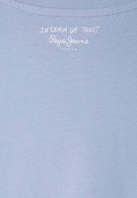 Světle modré bavlněné tričko s bílým potiskem "IN DENIM WE TRUST" a "Pepe Jeans LONDON" blízko výstřihu. Hladká textura.