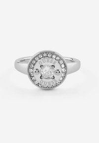 Anello in argento con una ghiera circolare al centro, dotata di una pietra chiara circondata da pietre più piccole, incisa con "GUESS" in due punti.