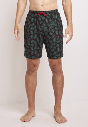 Zwemshorts met een zwarte achtergrond met groene dennenpatronen en rode bessen, elastische tailleband met een rode koord, snit boven de knie.