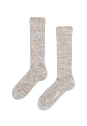 Beige gerippte Socken mit einem strukturierten Muster und kontrastierenden weißen Fäden. Das Design hat einen Bund oben und eine glatte Fußsohle.