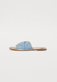 Blå lær slidesandaler med kryssbånddesign, flat tan såle og en metallisk gullakcent langs kanten. Jevn tekstur, åpen tå.
