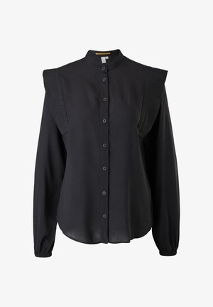 Chemise noire à col haut, avec des manches longues froncées et des accents texturés aux épaules. Fabriquée en tissu doux et léger.