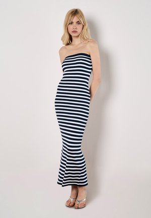 Robe maxi rayée et côtelée en bleu marine et blanc ; design sans bretelles ; ourlet évasé ; texture lisse ; complétée par des tongs argentées.