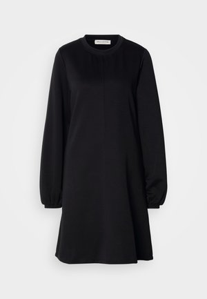 Zwarte jurk van zachte stof met een ronde halslijn, lange puffmouwen en een licht uitlopende silhoeët. Heeft een minimalistisch ontwerp.