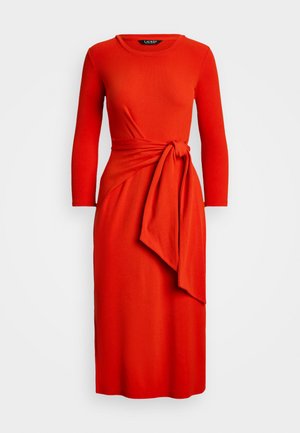 Vestido longo vermelho de mangas compridas com design envolvente e laço lateral. Textura suave, comprimento até ao joelho, decote redondo e silhueta ajustada.