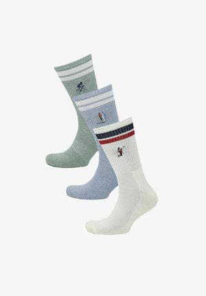 Drie paar crew-sokken in groen, blauw en wit met sportthema borduurwerk: fietser, surfer en golfer onder gestreepte boorden.