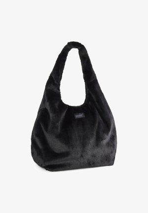 Sac à main Puma noir en fausse fourrure douce, avec une large bandoulière et une petite étiquette logo sur le devant.