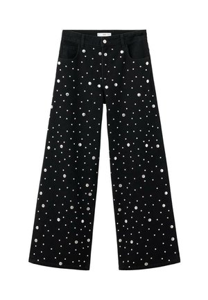 Jeans de pierna ancha negros con un patrón disperso de tachuelas plateadas, con bolsillos delanteros y un diseño tradicional de cinco bolsillos.
