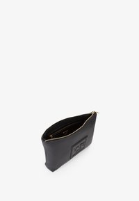 Pouch in pelle nera texture con chiusura a zip, dotato di una patch con marchio sulla parte anteriore. L'interno è foderato con un tessuto liscio.