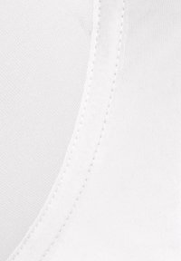 Witte stof close-up met een gladde textuur en zichtbare stiksels langs de rand, wat wijst op een aansluitend ontwerp en naadloze constructie.