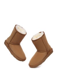 Sandfarbene Kunstwildleder-Stiefeletten mit weichem cremefarbenen Kunstfellfutter, flacher Gummisohle und runder Zehenform.