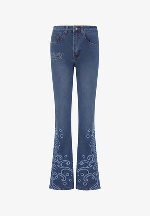 Siniset farkut, joissa on leveät lahkeet ja monimutkainen vaaleansininen brodeeraus lahkeiden alaosassa sekä logo-tyyli etutaskussa. Sileä pinta.