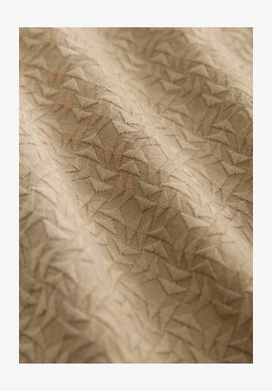 Beige stof med et struktureret mønster af sammenflettede trekanter, med en let glans og subtil broderidetaljering throughout.