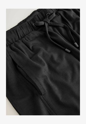 Melni kokvilnas šorti ar elastīgu jostu, aukliņu aizdari un sānu kabatām. Gluda tekstūra, ikdienišķs dizains, piemērots dažādām aktivitātēm.