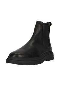 Svart läder Chelsea-boot med elastiska sidopaneler, kraftig gummisula och strukturerad yta, lätt vinklad åt höger mot en vit bakgrund.