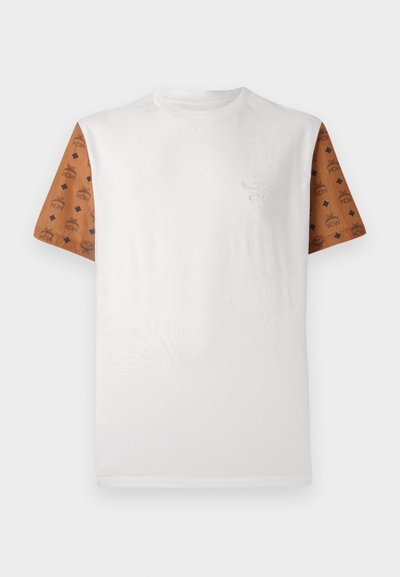 Majica s kratkimi rokavi z belo telesno barvo in vzorčenimi rjavimi rokavi, ki vsebujejo ponavljajoč se črni vzorček. Podroben logotip na prsih.