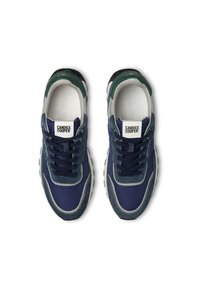 Baskets en suède et mesh bleu marine avec des accents verts, semelle blanche et lacets bleu marine ; dotées d'un patch logo sur la languette et de détails de couture.