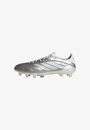 Silberner Adidas-Fußballschuh mit weißen Streifen, Schnürsenkeln und formgepressten Stollen für das Spiel auf festem Boden, im Profil von der rechten Seite gezeigt.