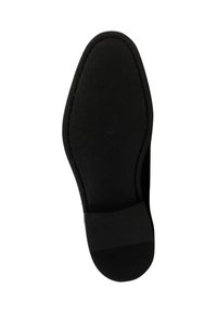 Sole di scarpa nera con una finitura liscia e opaca. Forma oblonga e tacco leggermente sollevato senza motivi visibili o dettagli hardware.