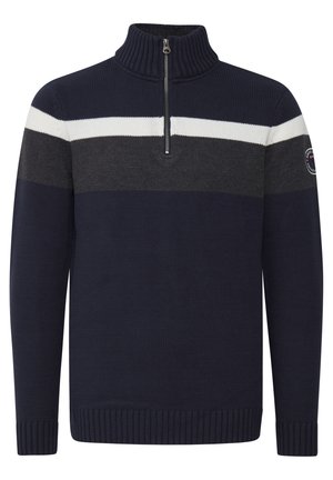 Marineblå strikkegenser med høy krage og frontglidelås. Har grå og hvite horisontale striper, samt ribbestrikkede ermer og nederkant.