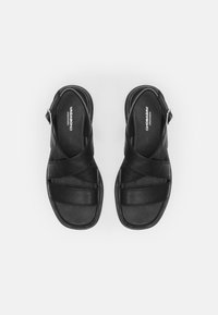 Black leather sandals featuring cross strap design, adjustable buckle, and a cushioned footbed with a smooth texture. Brand logo visible inside.