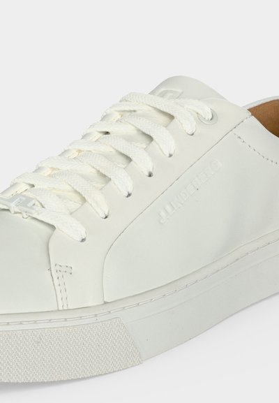 Άσπρο χαμηλό sneaker με υφασμένη λαστιχένια σόλα και λευκά κορδόνια, με διακριτικό ανάγλυφο λογότυπο στην πλαϊνή όψη.