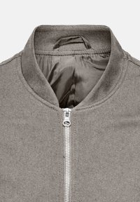 Grau gefütterte Jacke mit einem silbernen Reißverschluss und einem kurzen Stehkragen, die das glatte Innenfutter und einen Aufhänger im Kragen zeigt.