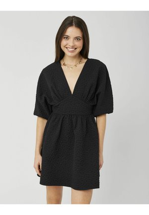 Robe noire avec un motif texturé et matelassé, décolleté en V profond, manches courtes bouffantes et taille froncée, avec une coupe mi-longue jusqu'aux genoux.