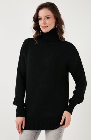 Musta ylisuuria turtleneck-neuletta pitkillä hihoilla, ribbausreunuksilla ja -helmalla, tekstuuri-neulekuvio, yhdistetty vaaleanharmaisiin farkkuihin.