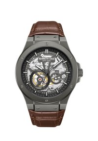 Automātiskās pulksteņi ar melnu skeleta ciparnīcu, sudraba toņa mehānismu, pelēku korpusu un brūnu krokodila raksta ādas siksnu.